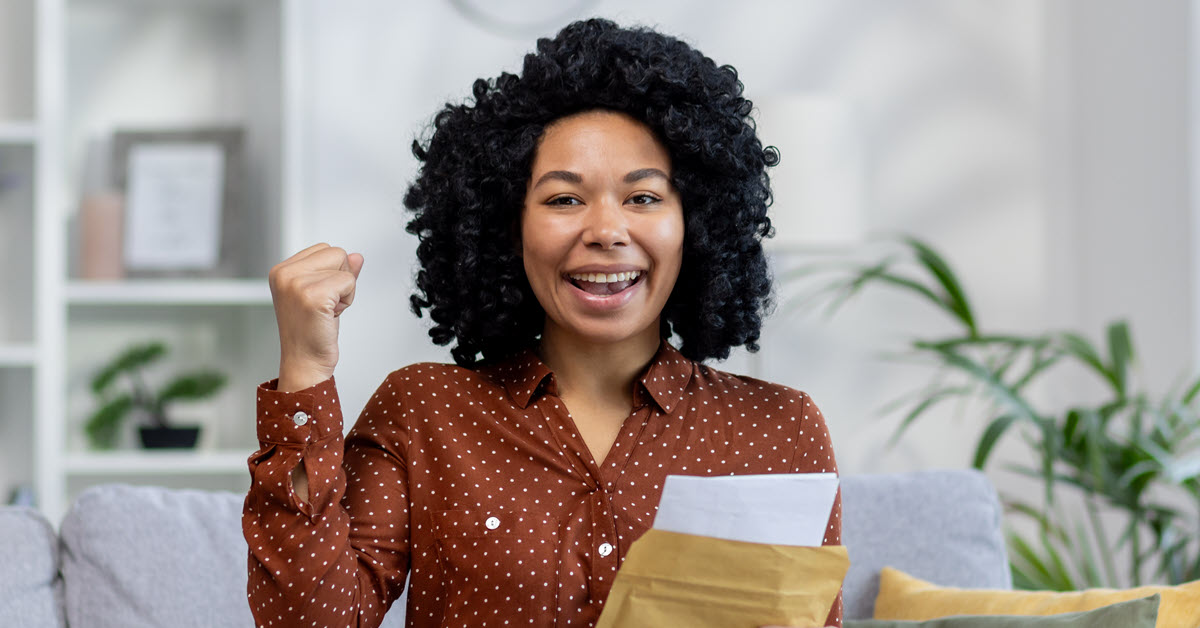 Woman has opened an envelope and is excited in victory