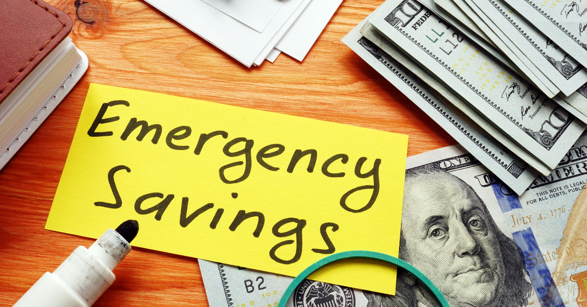 $100 bills on table and note with writing that says Emergency Savings